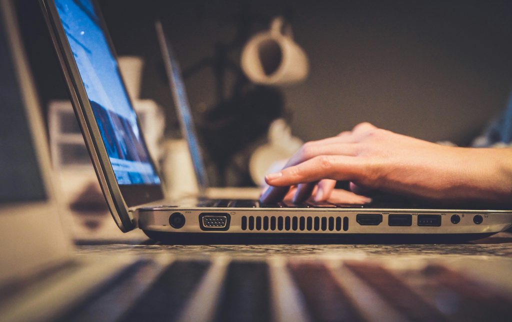 a person's hands possibly working with an online reputation management with rapid URL indexer on a laptop