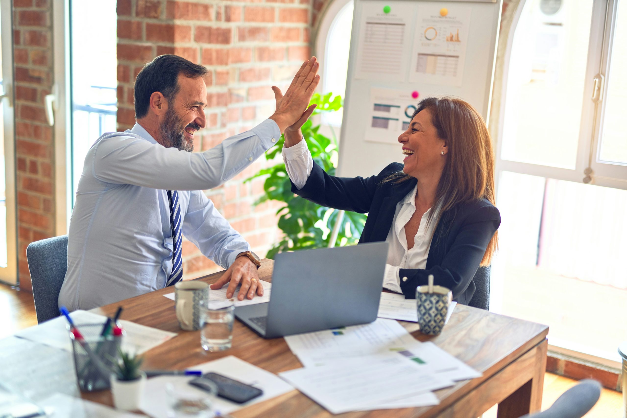 a small business financial advisor and a business woman giving each other a high five