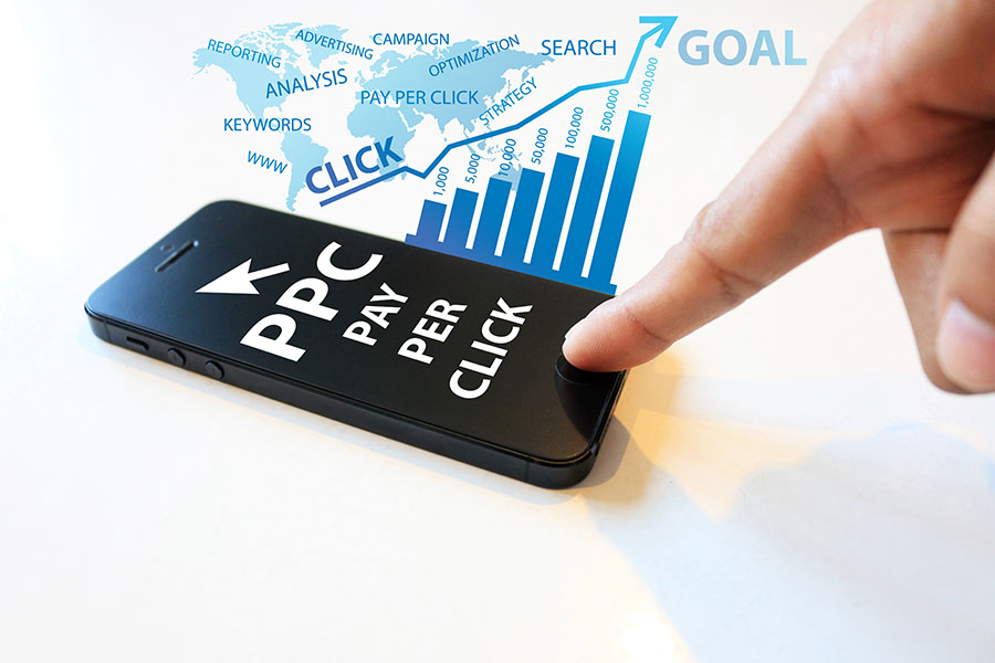 A finger hovers over a smartphone screen reading PPC Pay Per Click  